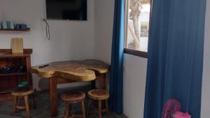 Cette chambre dispose d'une table en bois avec tabourets et d'une fenêtre. dans l'établissement Luz del Mar Bungalos en la playa del Paredón, à Sipacate