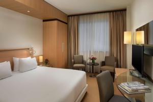 維拉諾瓦的住宿－博洛尼亞維拉諾瓦NH酒店，酒店客房设有一张白色大床和一张书桌