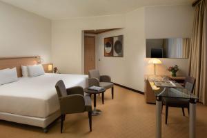 維拉諾瓦的住宿－博洛尼亞維拉諾瓦NH酒店，配有一张床和一张书桌的酒店客房