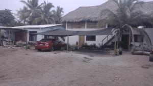 une maison avec une voiture garée devant elle dans l'établissement Luz del Mar Bungalos en la playa del Paredón, à Sipacate