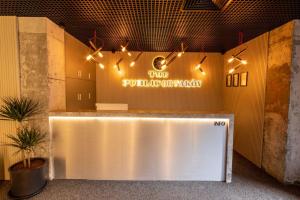 a lobby with a white reception counter with lights at The Public Ortakoy in Istanbul