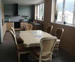 a dining room table with chairs and a kitchen at Apartment Isfjordsveien in Åndalsnes