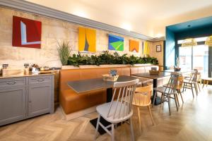 un restaurant avec des tables, des chaises et des peintures murales dans l'établissement Hotel de La Paix, à La Rochelle