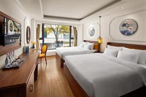 a hotel room with two beds and a desk at Eliana Premio Hotel Hanoi in Hanoi