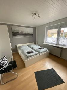 Vordorf的住宿－Gästehaus Brunswiek Erdgeschoss，一间卧室设有两张床、一把椅子和一个窗户。