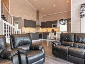 a living room with two leather chairs and a kitchen at Holiday Home Mökki tenolla by Interhome in Utsjoki