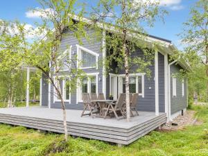 une maison avec une terrasse couverte dotée d'une table et de chaises dans l'établissement Holiday Home Mökki tenolla by Interhome, à Utsjoki