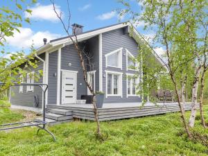a gray house with a porch and a yard at Holiday Home Mökki tenolla by Interhome in Utsjoki