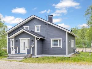 une maison grise avec une porte blanche et une terrasse couverte dans l'établissement Holiday Home Mökki tenolla by Interhome, à Utsjoki