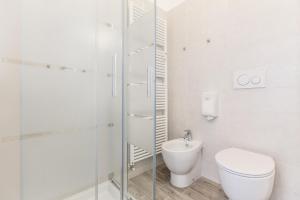 ein weißes Bad mit einem WC und einer Dusche in der Unterkunft Central City Rooms m09 Apartment in Bologna