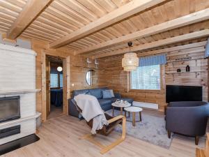 een woonkamer in een blokhut met een bank en een tv bij Holiday Home Kultahiekka by Interhome in Kivilahti