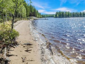 a sandy beach next to a body of water at Holiday Home Kultahiekka by Interhome in Kivilahti