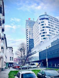 a city with cars parked in front of a large building at Bratislava City Center in Nivy