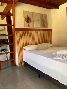 a large bed in a room with a ladder at Recanto Fiel in Itacaré