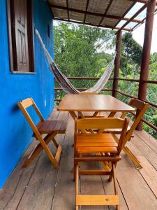 a hammock and a table and chairs on a porch at Recanto Fiel in Itacaré