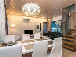 a dining room with a white table and white chairs at Holiday Home Villa joutseno by Interhome in Imatra