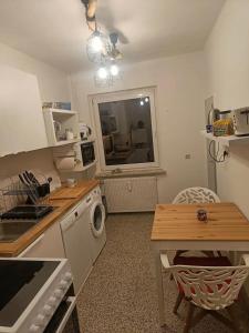 eine Küche mit einer Waschmaschine und einem Tisch in der Unterkunft Brunswick Central Charm: Cozy City Room! in Braunschweig