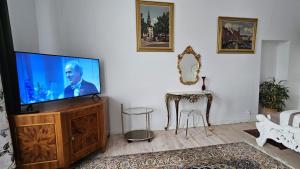 ein Wohnzimmer mit einem Flachbild-TV auf einem hölzernen Entertainment-Center in der Unterkunft Apartament Przy Jeziorze in Ostróda