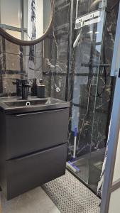 ein Bad mit einem Waschbecken und einer Glasdusche in der Unterkunft Apartament Przy Jeziorze in Ostróda