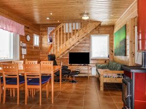a living room with a dining room table and a television at Holiday Home Lomahuoneisto b by Interhome in Utsjoki