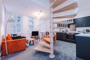 a kitchen and a living room with a spiral staircase at The Old Embassy by Guestz in Hull