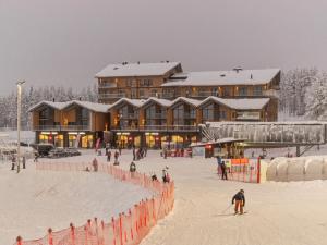 a group of people skiing in the snow in front of a lodge at Holiday Home Cranberry c4 by Interhome in Sirkka