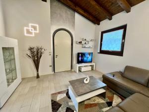 ローヴェレにあるIl Bacio del soleのソファとテレビのあるリビングルーム