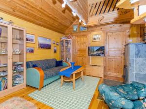 a living room with a blue couch and a table at Holiday Home Villa käpytikka by Interhome in Ylämylly