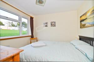 Schlafzimmer mit einem Bett und einem Fenster in der Unterkunft 117 Sandown Bay in Sandown