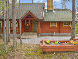 une maison avec un bac à sable en face de celle-ci dans l'établissement Holiday Home Villa käpytikka by Interhome, à Ylämylly