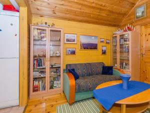 uma sala de estar com um sofá e uma mesa em Holiday Home Villa käpytikka by Interhome em Ylämylly