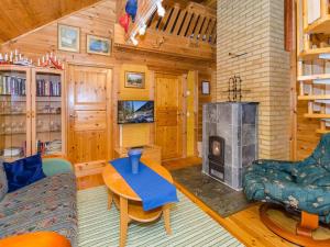 a living room with a fireplace in a cabin at Holiday Home Villa käpytikka by Interhome in Ylämylly