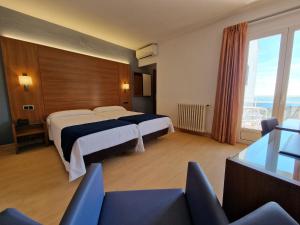 a hotel room with two beds and a large window at Hotel Sant Jordi in Tarragona