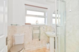 ein Bad mit einem WC, einem Waschbecken und einem Fenster in der Unterkunft 117 Sandown Bay in Sandown