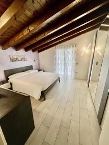 ローヴェレにあるIl Bacio del soleの大きなベッドと窓のある寝室