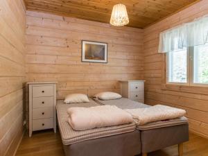 1 Schlafzimmer mit 2 Betten in einem Blockhaus in der Unterkunft Holiday Home Koivuranta by Interhome in Lamppi