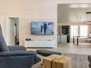 a living room with a tv on a wall at Holiday Home Palanteen haavelinna by Interhome in Eräjärvi