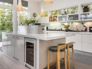 eine Küche mit weißen Schränken und eine große Insel mit zwei Barhockern in der Unterkunft Holiday Home Villa katarina by Interhome in Nauvo