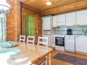 cocina con mesa de madera y armarios blancos en Holiday Home Paju 7 by Interhome, en Isnäs