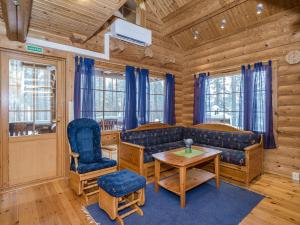 uma sala de estar com um sofá, uma mesa e cadeiras em Holiday Home Villa tunturitervakko by Interhome em Ylämylly