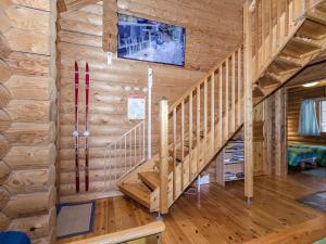 eine Treppe in einem Blockhaus mit einem Flachbild-TV in der Unterkunft Holiday Home Villa tunturitervakko by Interhome in Ylämylly