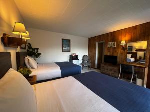 una camera d'albergo con due letti e una televisione di Nocturne Motel a New Smyrna Beach
