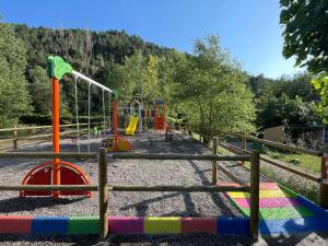 um parque infantil num parque com uma cerca em Bungalows Pont d'Ardaix em El Pont de Bar