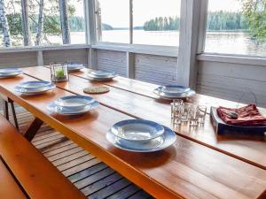 una mesa de madera con platos y vasos. en Holiday Home Purjeranta by Interhome, en Koirakivi