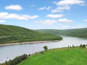 a river in the middle of a green valley at Holiday Home Nilla 3 by Interhome in Utsjoki