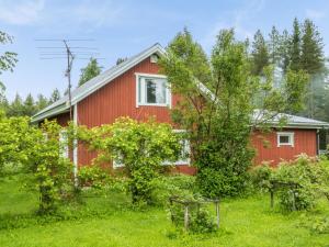 een rood huis met bomen ervoor bij Holiday Home Käpylä by Interhome 
