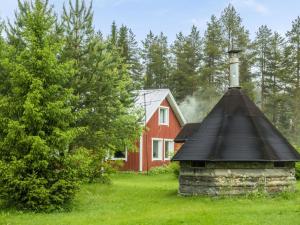 een rood huis met een zwart dak en een schoorsteen bij Holiday Home Käpylä by Interhome 