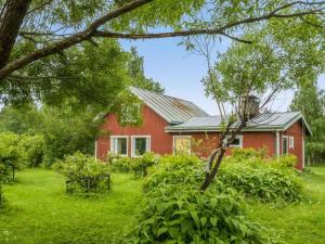 een rood huis met een tuin ervoor bij Holiday Home Käpylä by Interhome 
