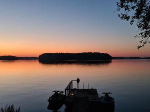 einen Sonnenuntergang auf einem See mit einem Dock im Wasser in der Unterkunft Holiday Home Lisan ranta by Interhome in Toijala