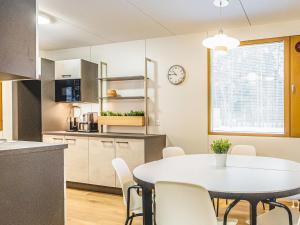 - une cuisine et une salle à manger avec une table et des chaises dans l'établissement Holiday Home Mäntyranta 4 by Interhome, à Punkaharju